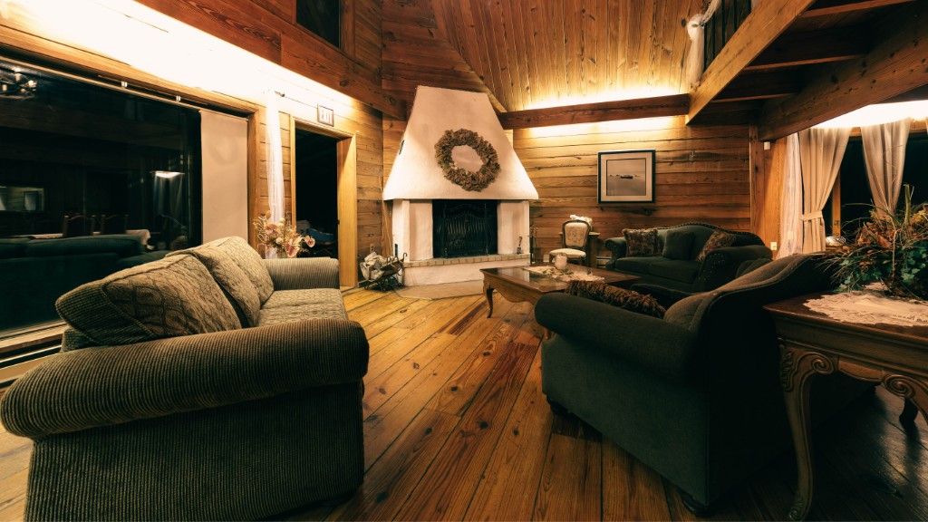 Living room with log walls, forest green seating and white fireplace, fictional PEAK project in Dorking