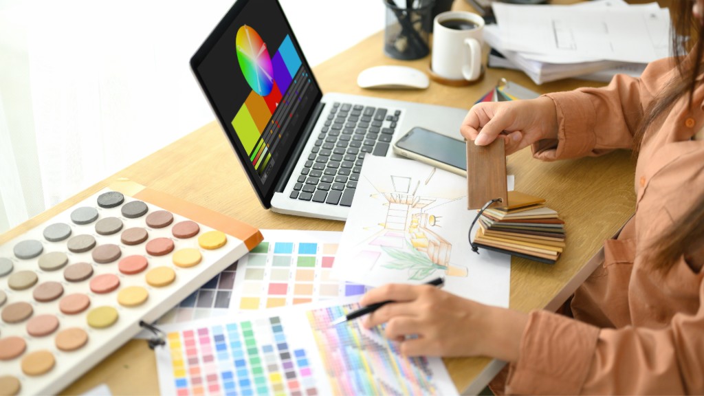 Designer reviewing material samples and sketches at a desk, PEAK studio process
